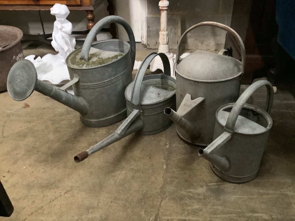 Two galvanised tubs, larger width 80cm, together with four watering cans